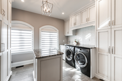 Designs by Santy :: Traditional Luxury Upstairs laundry with arch windows, folding table and millwork